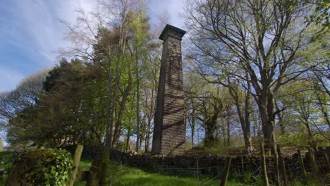 panning wide shot of a disused brick chimney at lumsdale waterfalls, matlock