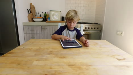 young boy using tablet computer in kitchen, zoom