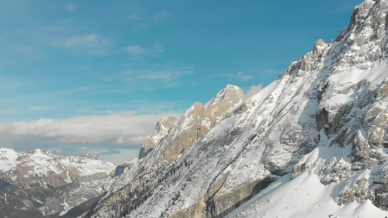 Un drone riprende una lenta panoramica delle Dolomiti innevate, con il Gran Vernel in Trentino, visto dalla zona di Ciampac