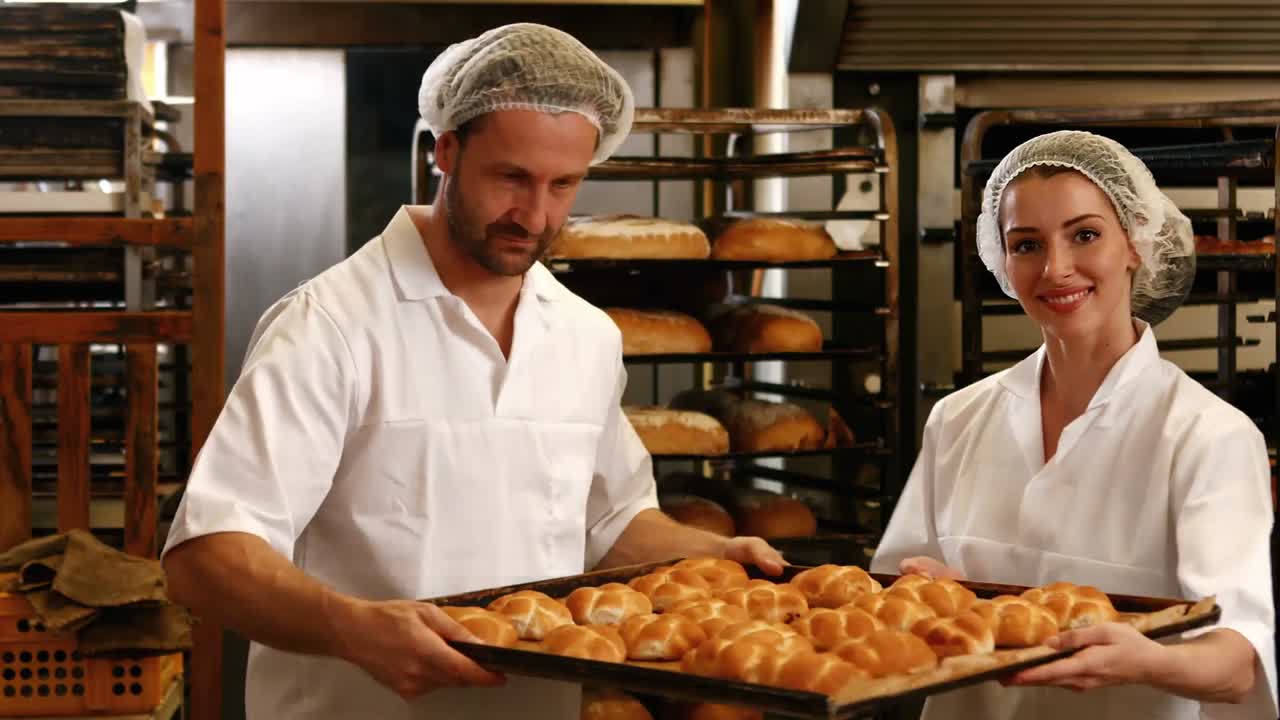 Bakers removing baked michetta from baking trolley