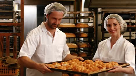 bakers removing baked michetta from baking trolley