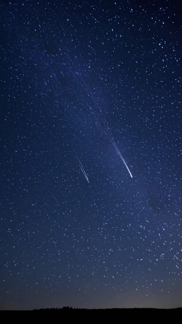 A stunning night sky filled with stars and a shooting star, captured from a low-angle