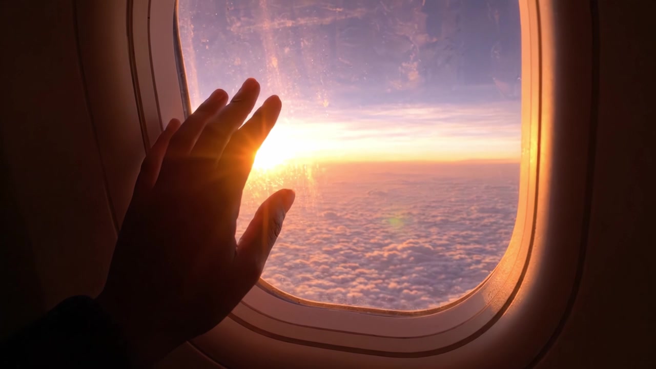 Capturing the Beauty of Dawn from an Airplane Window: A Serene Moment of Transition Between Night and Day Above the Clouds