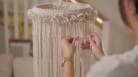 home hobby, knitting macrame. women's hands knit an ornament with thick threads.