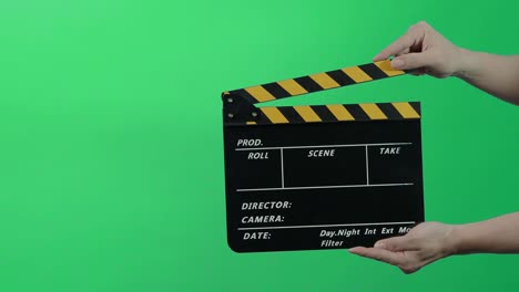 film slate or movie clapperboard with blue green screen background. film crew man hold and hit film slate in the frame. clapping film slate. video production chroma key background. video production.