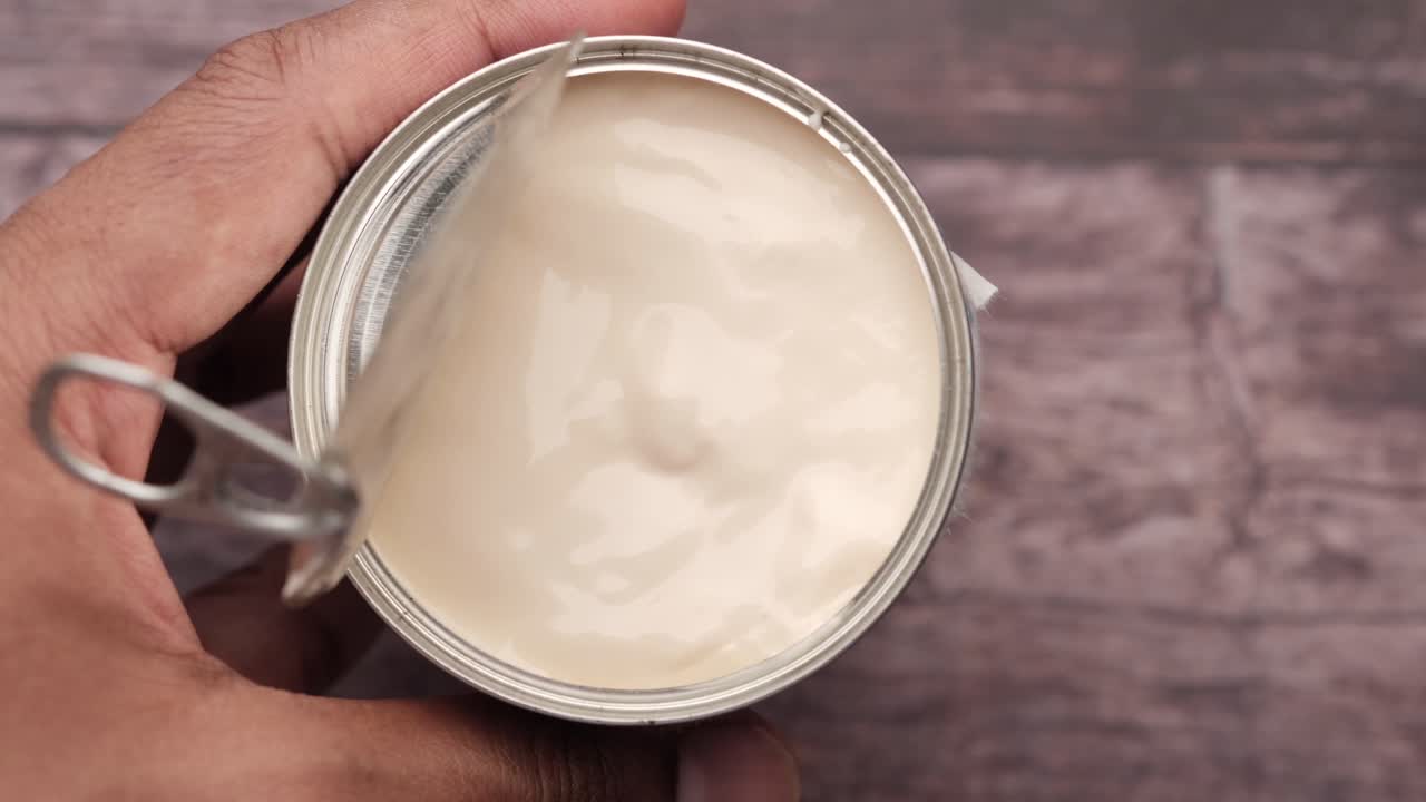 apertura de una lata de leche condensada o crema