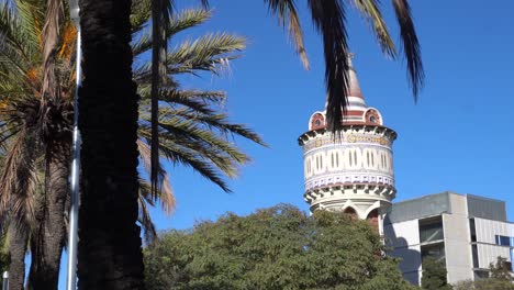 water tower seen through palm tree branches in barcelona on a clear day