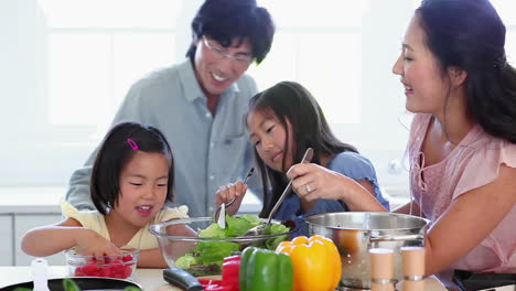 family work together to make a salad