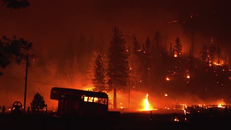 ranch brûlant au milieu d'une forêt rougeoyante et enfumée dans l'ouest des états-unis