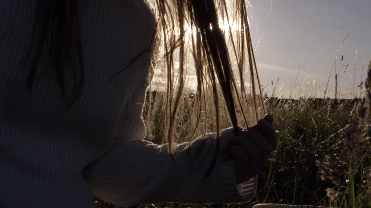 Woman playing with long hair in sunset medium shot
