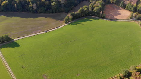 vista aérea sobre el campo verde y los coches que circulan por las carreteras rurales