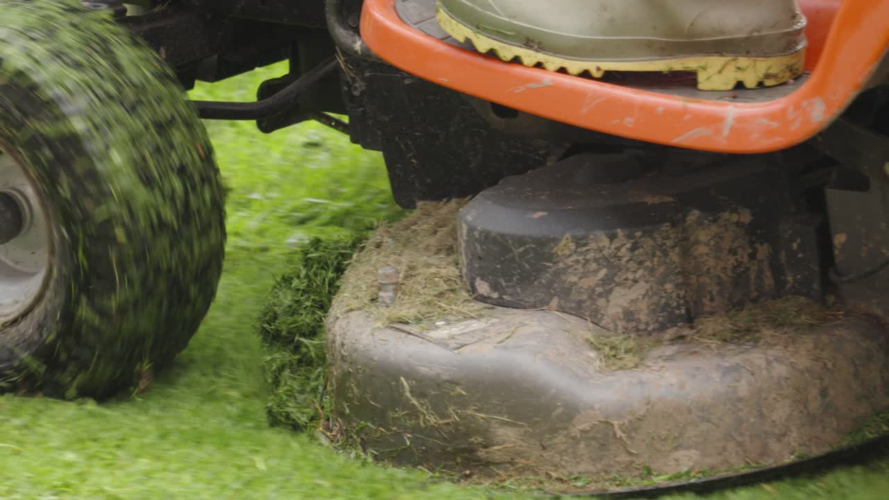 Tyre Close-up of Ride-on Lawn Mower Moving Forward Cutting Grass in Slow Motion. Perfect for gardening, landscaping, or satisfying nature visuals