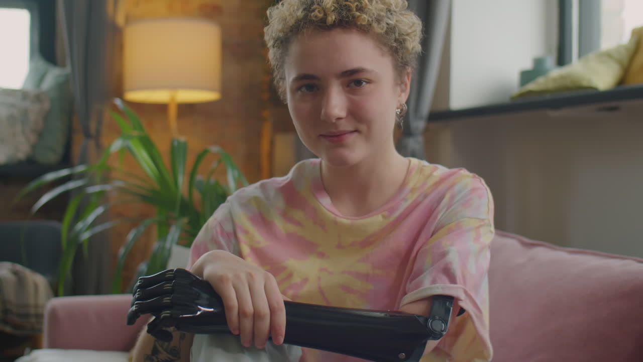 Portrait of Cheerful Girl with Prosthetic Arm at Home