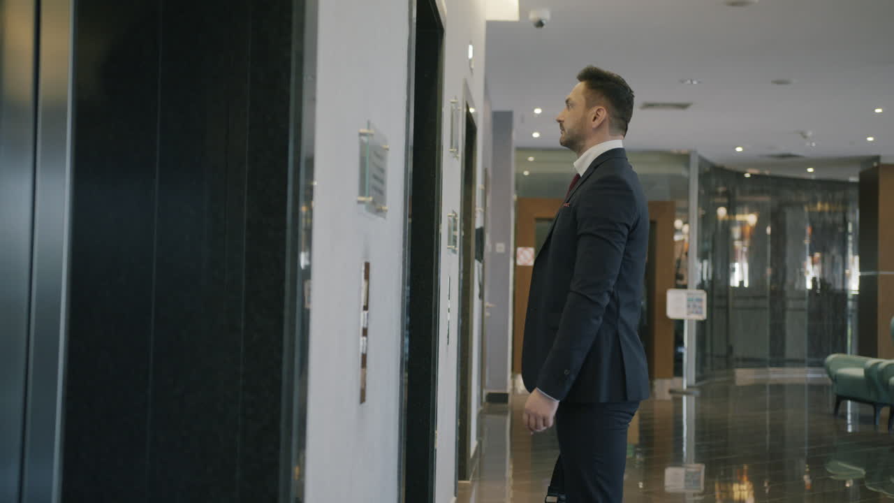 Businessman waiting for elevator in hotel lobby