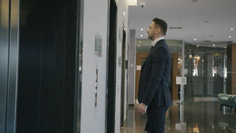 businessman waiting for elevator in hotel lobby
