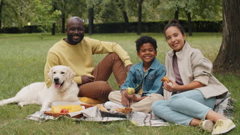 Retrato-De-Una-Alegre-Familia-Afroamericana-Con-Un-Perro-En-Un-Picnic-En-El-Parque