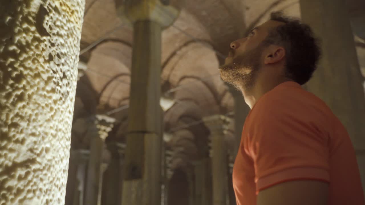 역사적인 장소의 기둥에 손을  ⁇ 은 사람.