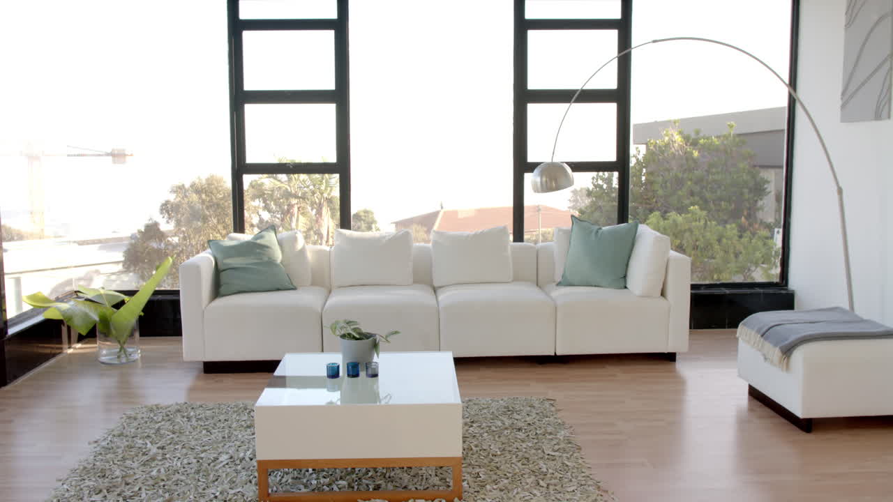 Modern living room with white sofa, large windows, and stylish decor elements, copy space