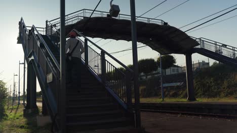pasajero que se dirige a través de la brecha de la plataforma en la estación de tren del pueblo