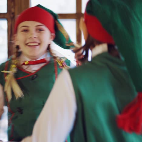 funny elves with long ears are looking out the window in anticipation of the holiday and dancing together on the background of new year's decorations. blurred background. close-up