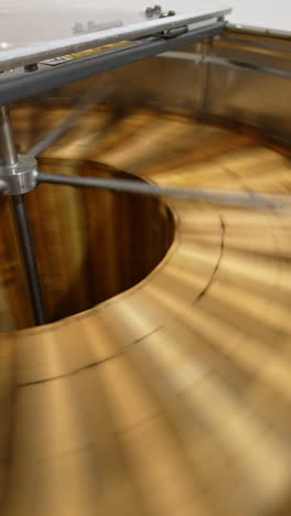 working machine for extraction of honey at apiary. centrifuge apparatus rotates multiple wooden frames to remove honey. top view. vertical video