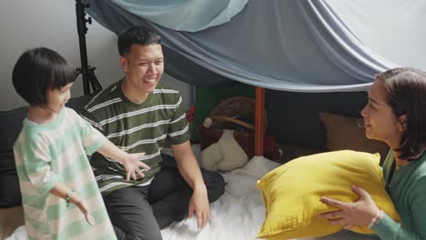 Happy-Young-Asian-Family-Spending-Time-Together-Playing-With-Pillow-At-Home