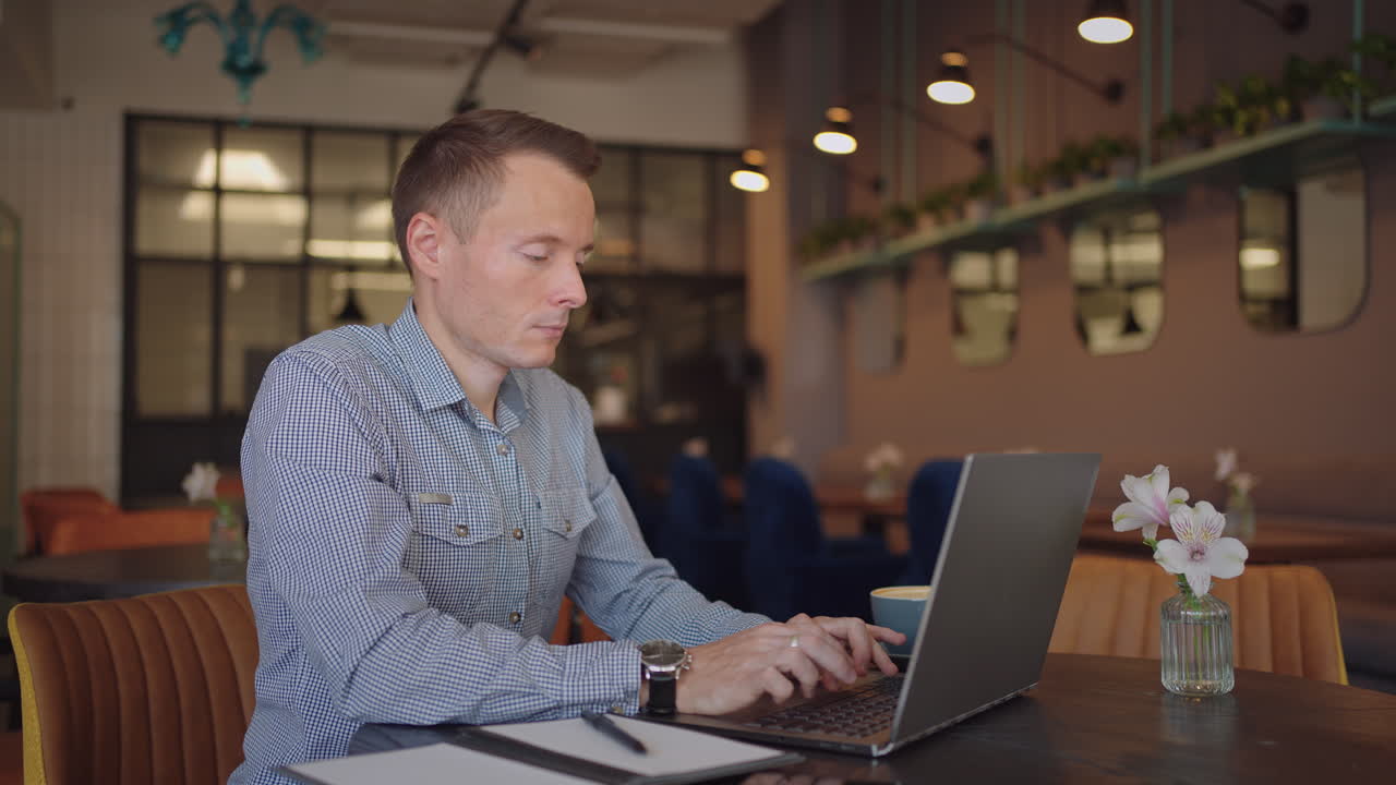 beautiful male developer or student working studying by laptop in cafe. freelance remote work online education self employed