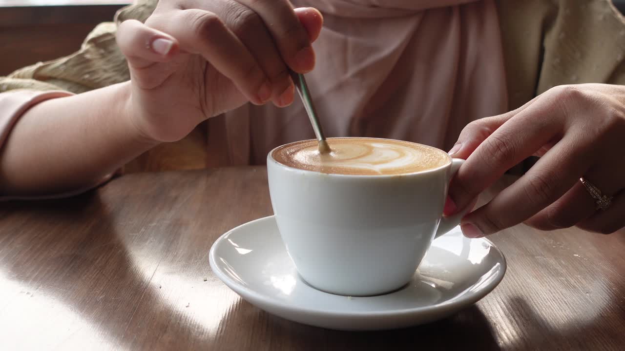 Woman enjoying a cup of latte art coffee in a cafe