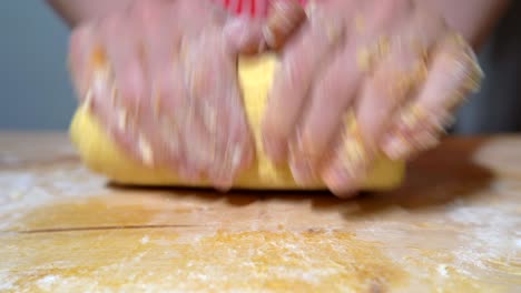 las manos de la mujer amasan la masa en una tabla de madera. receta de panadería