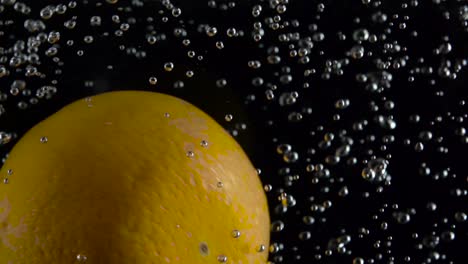 orange falls under the water on air bubbles in the water isolated on black background orange falls under the water on air bubbles in the water isolated on black background