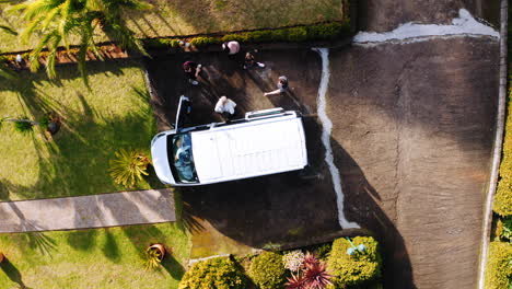 Vista-Aérea-Sobre-La-Gente-Que-Sale-De-Una-Furgoneta-Estacionada---Destornillador,-Disparo-De-Drones