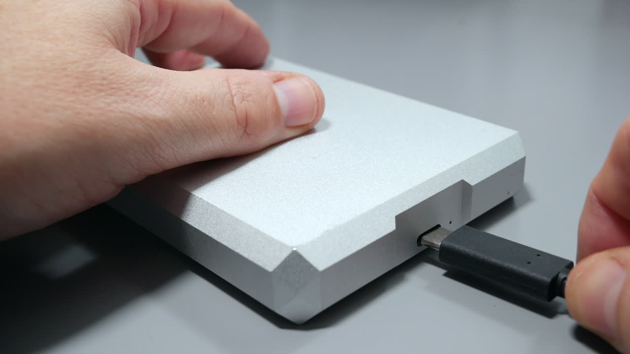 usb c 케이블을 휴대용 하드 드라이브 저장 장치에 손으로 연결