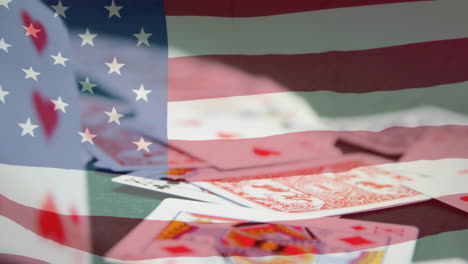 animation of playing cards falling over american flag waving