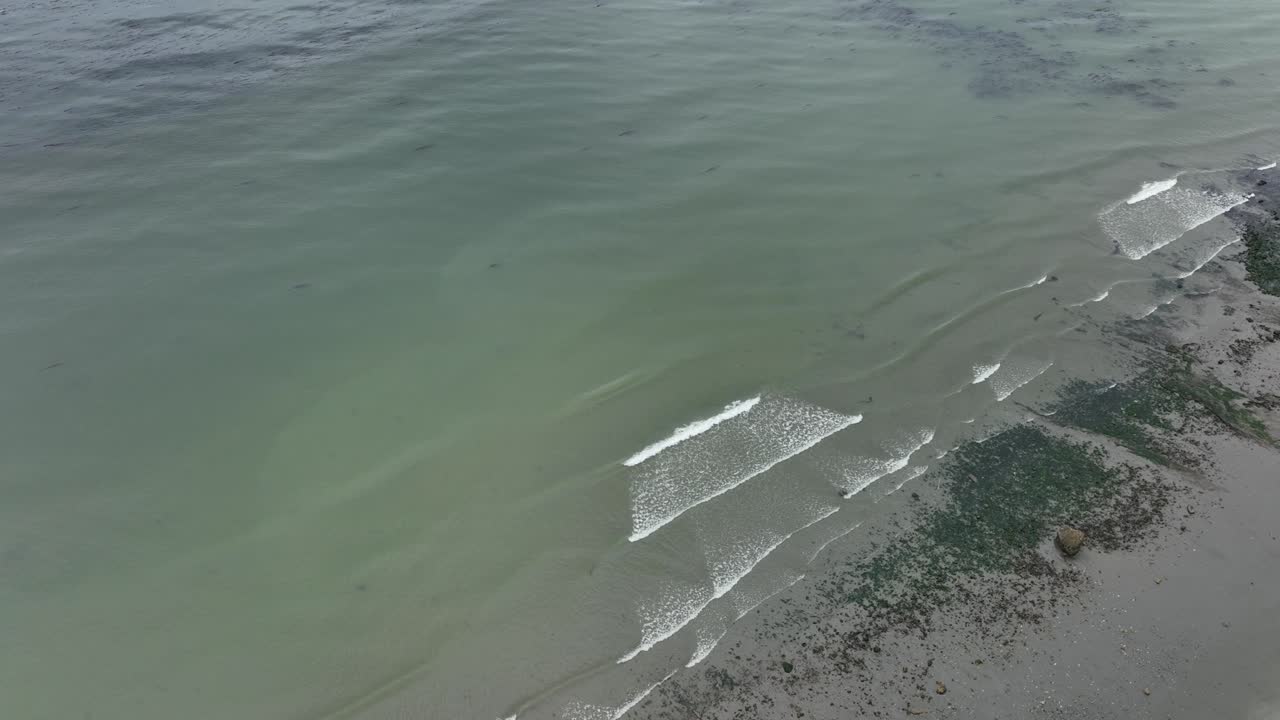 위드비 섬의 모래사장에 부서지는 파도의 조감도