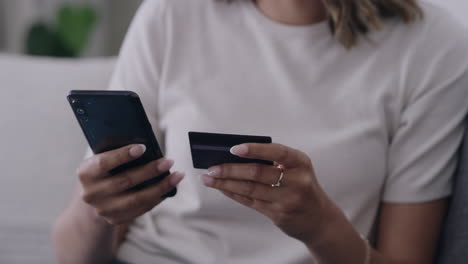 mano de mujer usando un teléfono y tarjeta de crédito