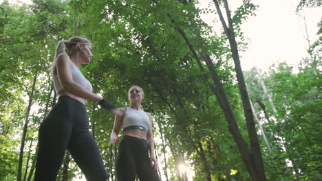 Zwei-Wunderschöne-Blonde-Sportlerinnen-Geben-High-Five-Und-Laufen-Gemeinsam-Im-Park-Los