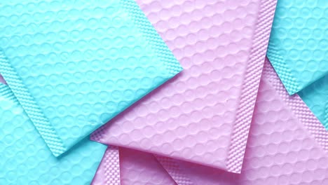 pink and v blue paper bubble envelope on table