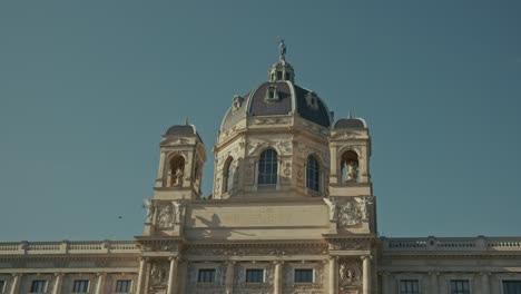 cúpula ornamentada del museo y estatuas bajo un cielo despejado en viena, austria