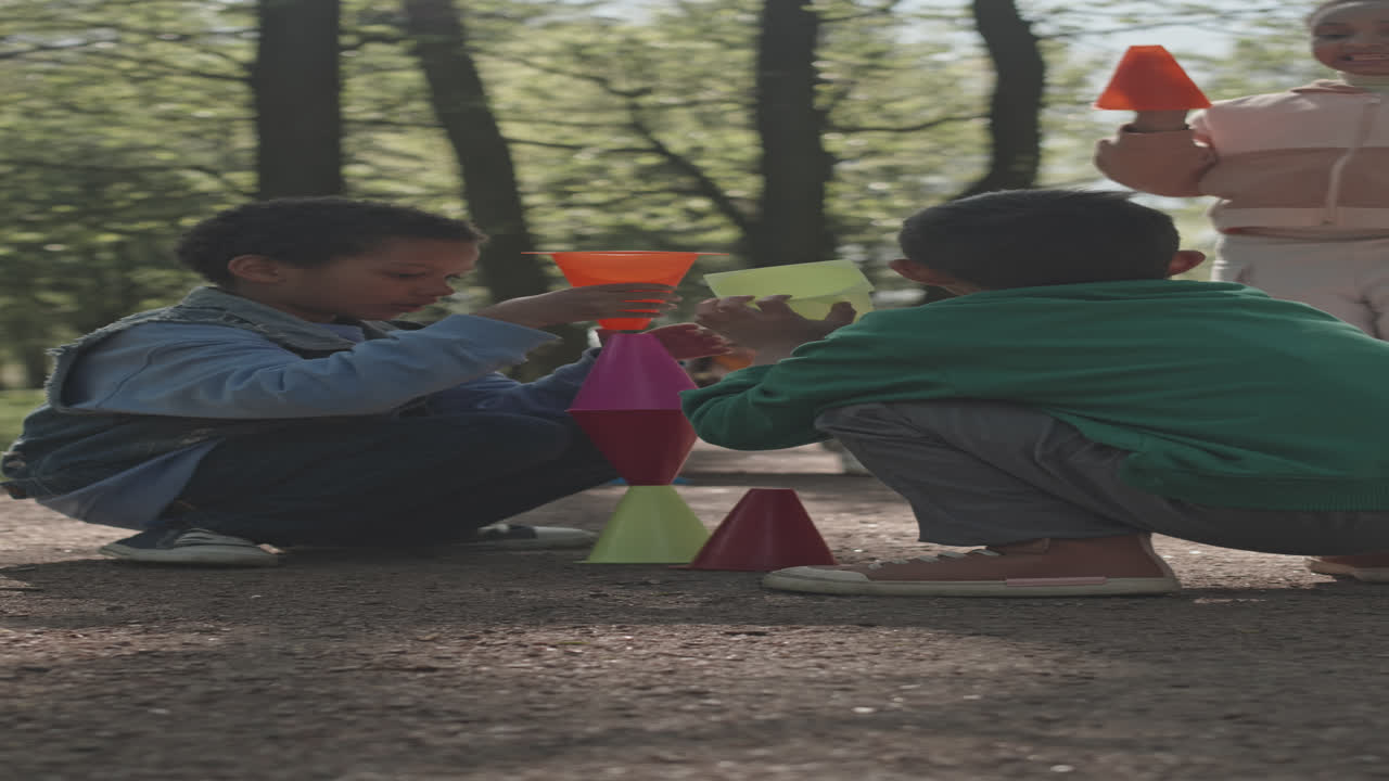 Little Kids Playing with Plastic Cones in Park