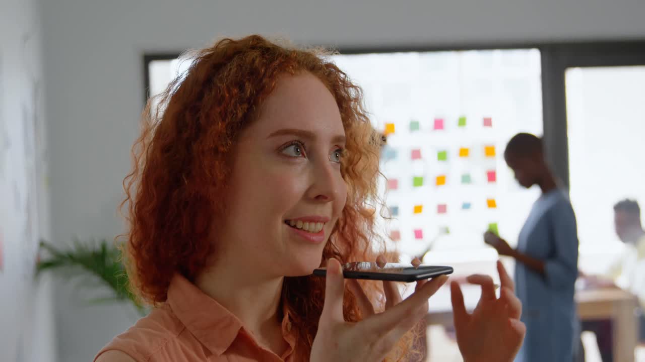 vista frontal de una joven mujer de negocios caucásica hablando por teléfono móvil en una oficina moderna 4k