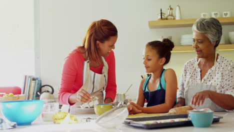 Happy-multi-generation-family-preparing-gingerbread-in-kitchen-4k