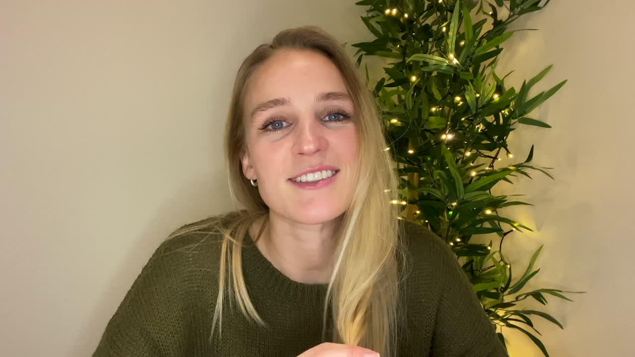 mujer joven en videollamada contando una historia a sus amigos directamente a la cámara