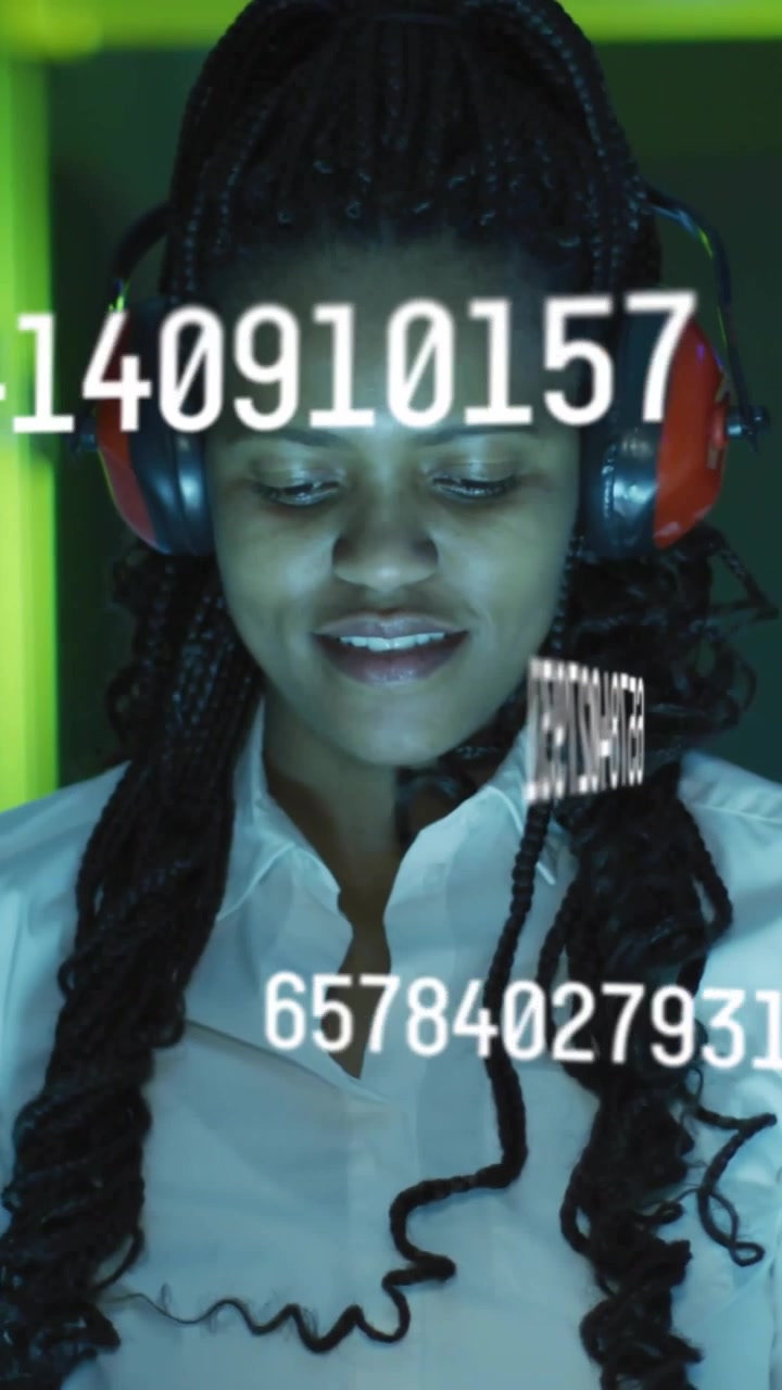 Vertical video: Data appearing, woman with red headset watching scrolling numbers for review