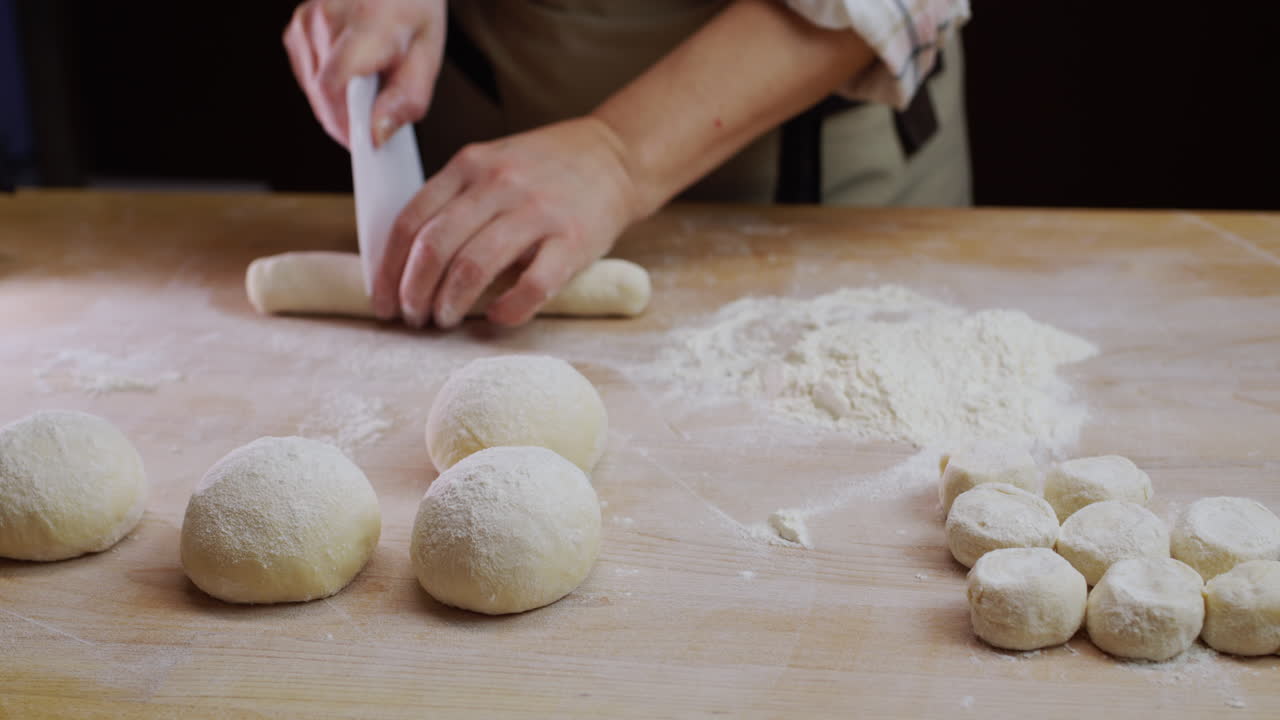 пекарь посыпает мукой неопеченные выпечки