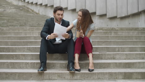 smiling businesspeople discussing documents