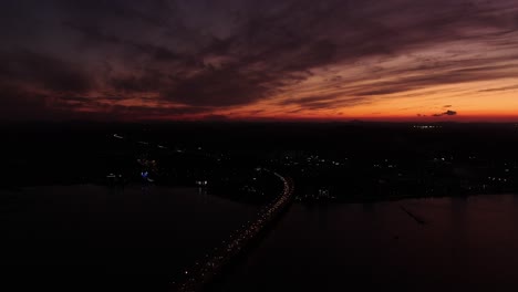 a bridge over which the sun sets and a panoramic view of the sea