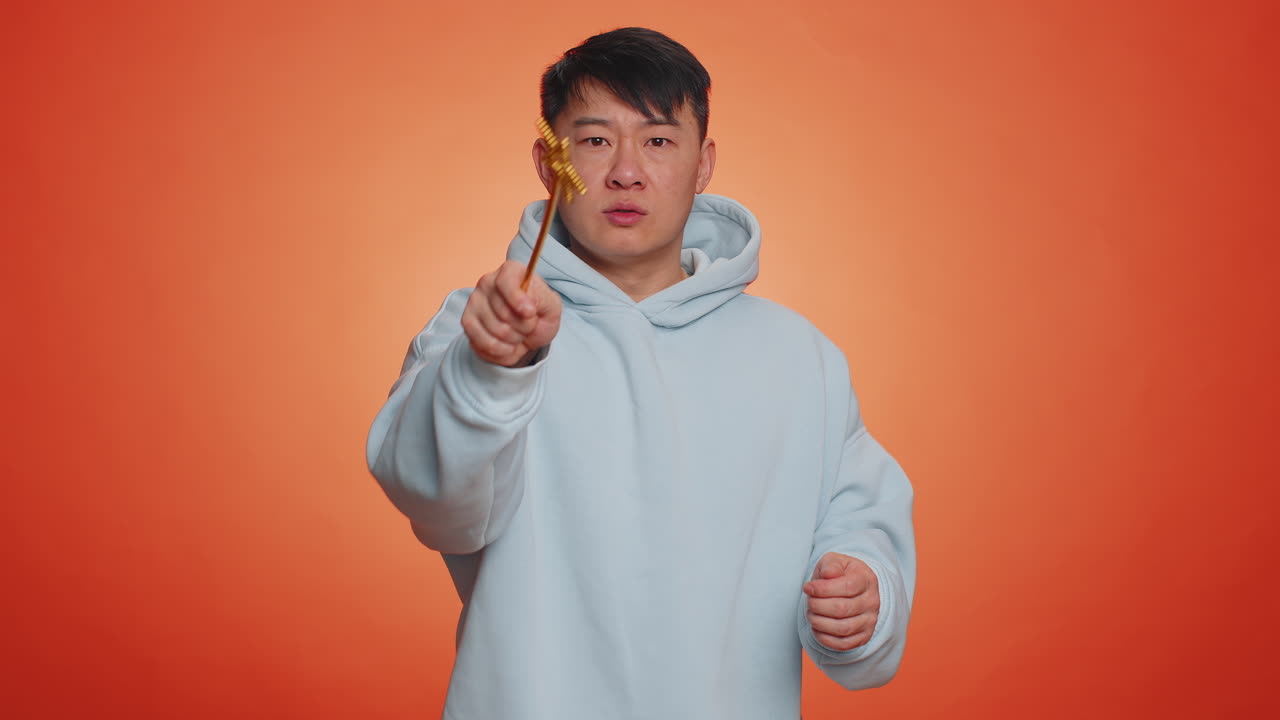 Magician wizard asian man gesturing with magic wand making wish come true casting magician spell