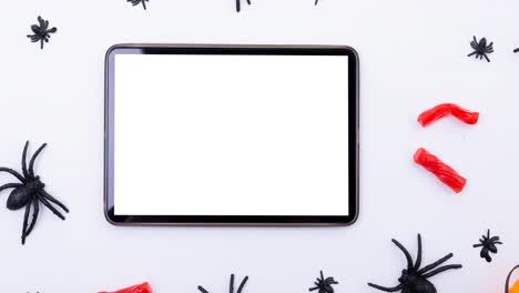 Animation-of-tablet-and-spiders-on-white-background