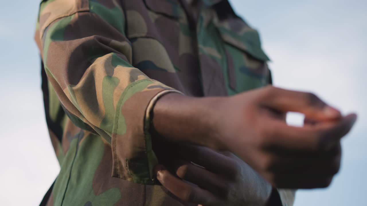 Special Forces Member Adjusting Camouflage Gear, Combat Soldier Preparing For Mission With Focused Anticipation, Elite Mercenary Tightens Camouflage Sleeve As Sky Watches In Quiet Readiness