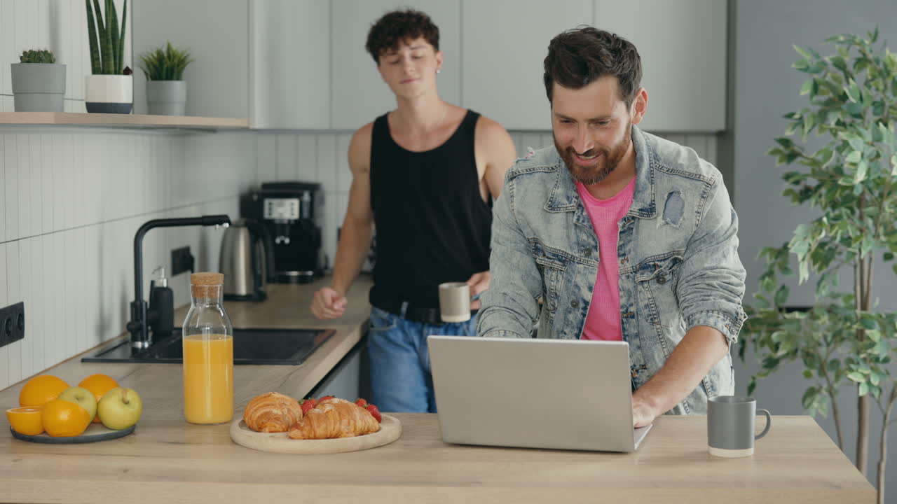 Happy Gay Couple Enjoying Breakfast and Working Together